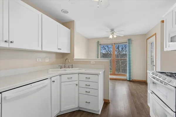 a kitchen with granite countertop a sink cabinets and wooden floor