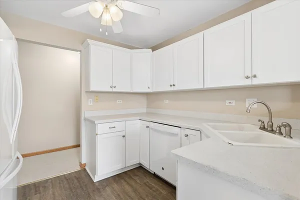 a kitchen with white cabinets and sink