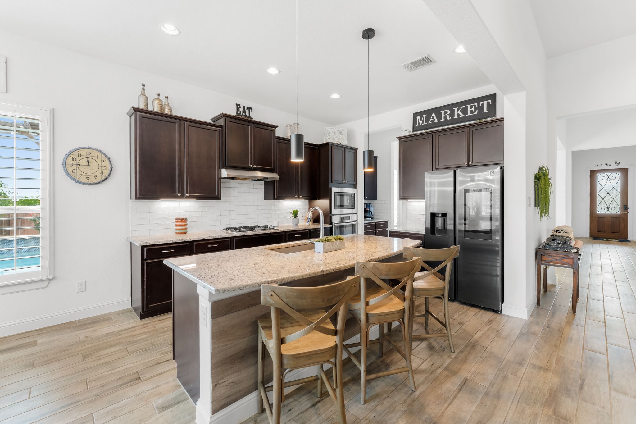 140 Waterloo Cove Georgetown, TX 78628 - Photo 7 of 40 A well-appointed culinary space featuring rich cabinetry, a central island with seating, and integrated modern appliances.