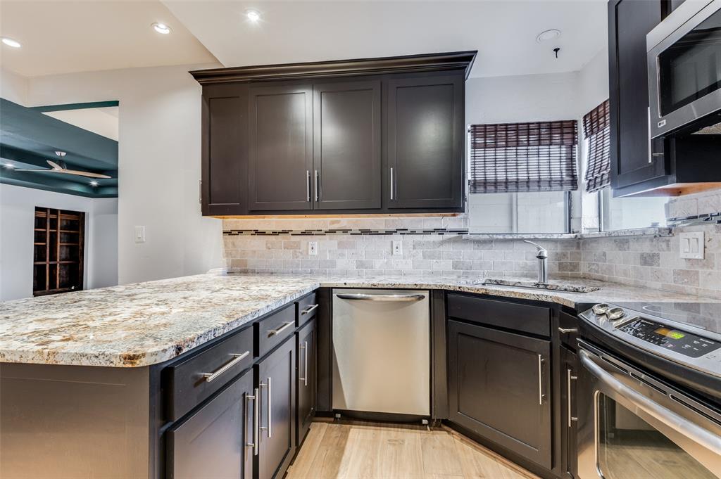 2749 Buna Drive Dallas, TX 75211 - Photo 7 of 12 Kitchen with stainless steel appliances, light stone counters, light wood-style floors, recessed lighting, and decorative backsplash