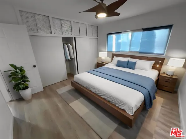 a bedroom with a bed and a potted plant