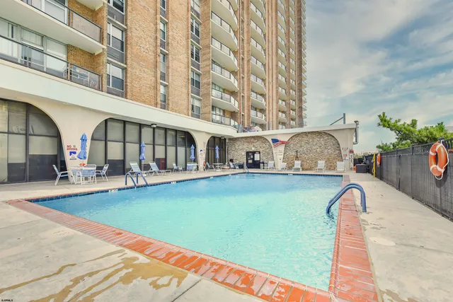 a view of swimming pool with outdoor seating and a garden