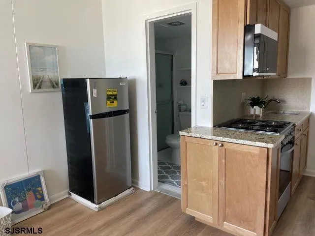 a kitchen with stainless steel appliances granite countertop a refrigerator and a stove