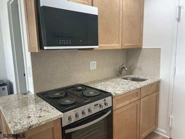 a stove top oven sitting inside of a kitchen