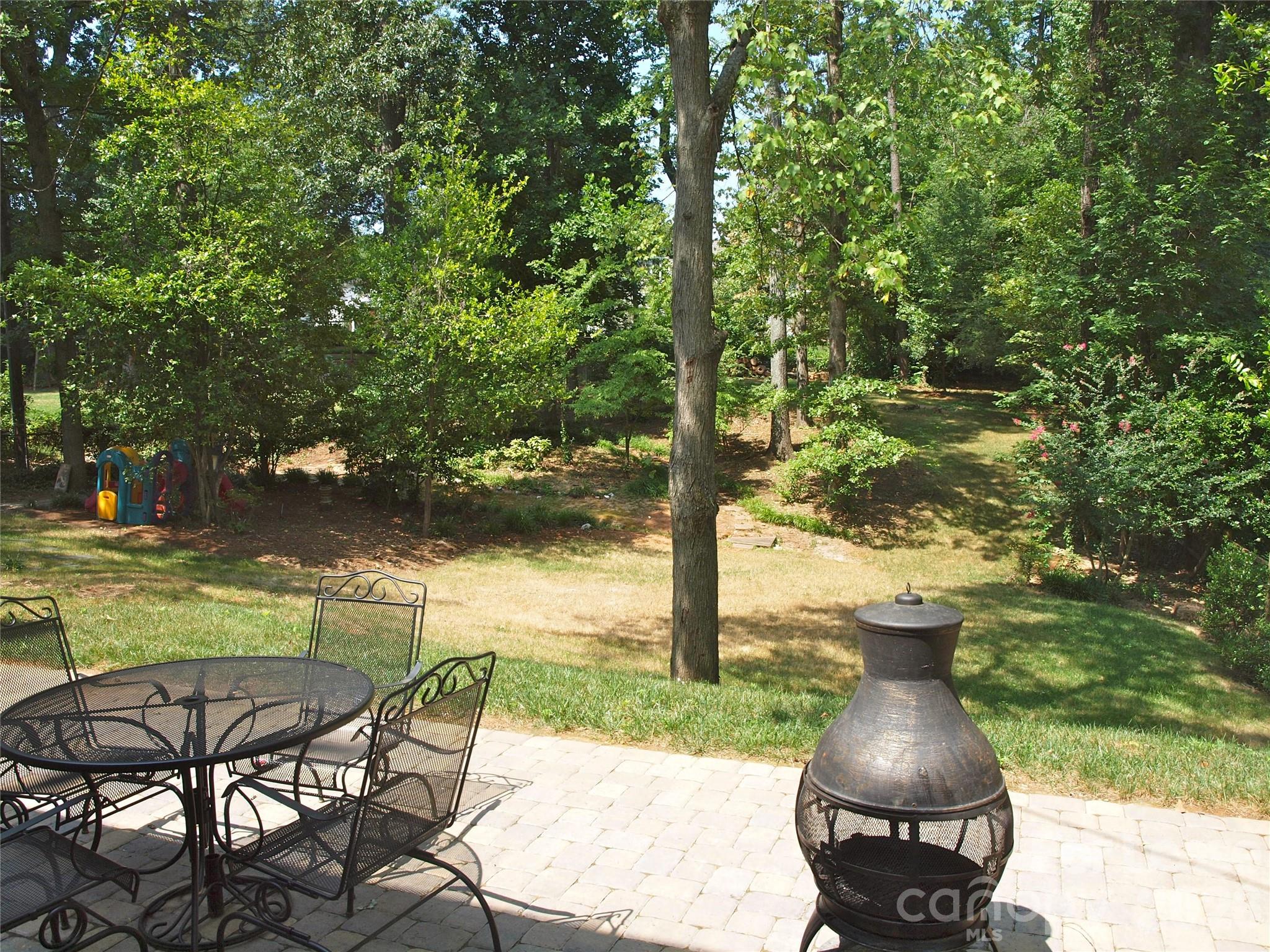 3922 Fellsway Road Charlotte, NC 28209 - Photo 15 of 31 a view of a lake with a table and chairs under an umbrella