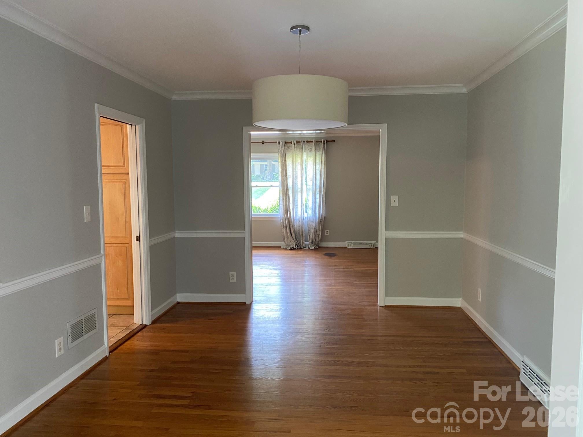 3922 Fellsway Road Charlotte, NC 28209 - Photo 17 of 31 an empty room with wooden floor chandelier and windows