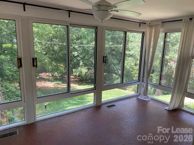 a view of an empty room with wooden floor and a floor to ceiling window