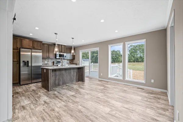 a kitchen with a refrigerator sink cabinets and wooden floor