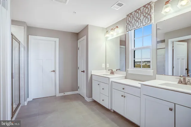 a bathroom with double sink and a mirror