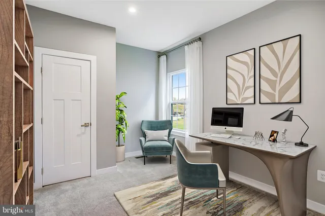 a work room with furniture a rug and a window