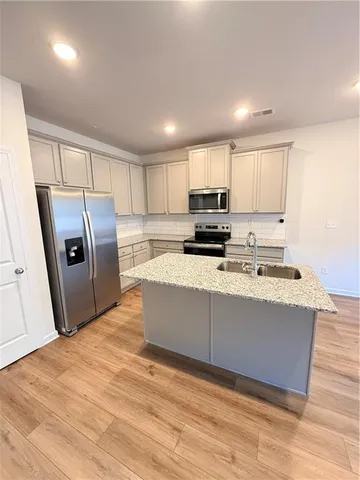 a kitchen with stainless steel appliances granite countertop a refrigerator sink and microwave