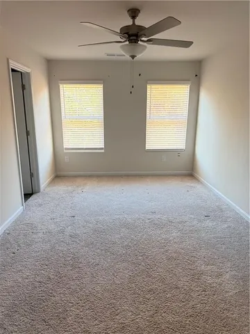 an empty room with windows and cabinet