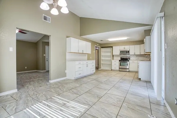 a kitchen with white cabinets and stainless steel appliances