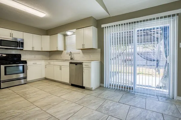a kitchen with kitchen island granite countertop a stove top oven sink and cabinets