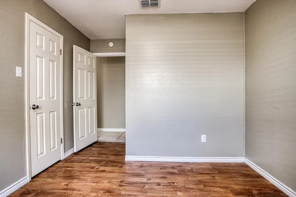 a view of a kitchen with white cabinets and a wooden floor
