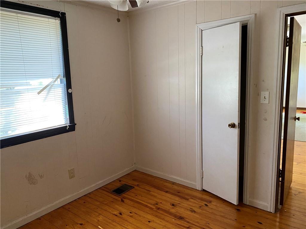 a view of a small space with wooden floor and a window