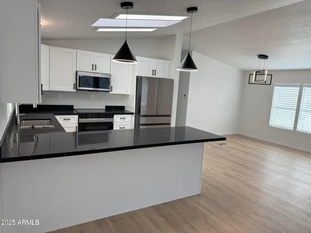 a kitchen with stainless steel appliances granite countertop a stove a sink and a microwave