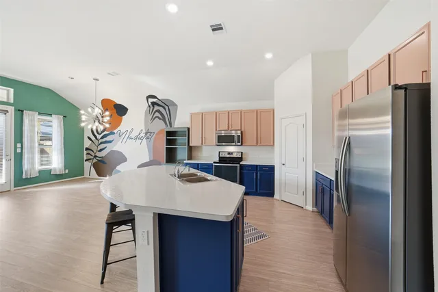 a kitchen with stainless steel appliances granite countertop a refrigerator and a sink