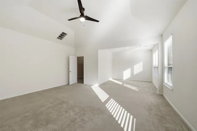 a view of a big room with a chandelier fan and windows