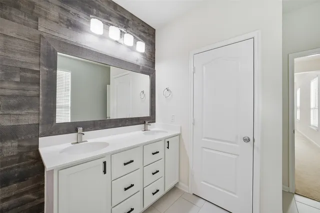 a bathroom with a double vanity sink and a mirror