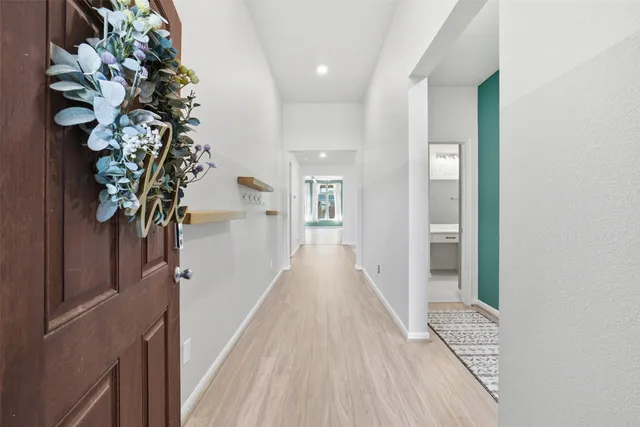 a view of a hallway with wooden floor and staircase