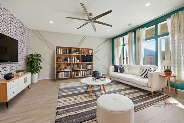a living room with furniture a flat screen tv and a large window