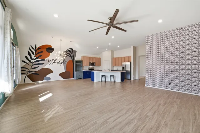 a view of a room with wooden floor and ceiling fan