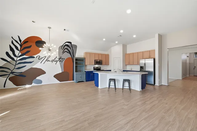 a kitchen with stainless steel appliances kitchen island granite countertop a sink and cabinets