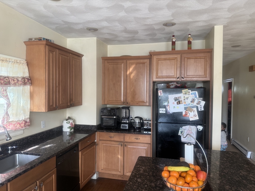82 2nd Street Medford, MA 02155 - Photo 11 of 38 a kitchen with stainless steel appliances granite countertop a sink stove and refrigerator