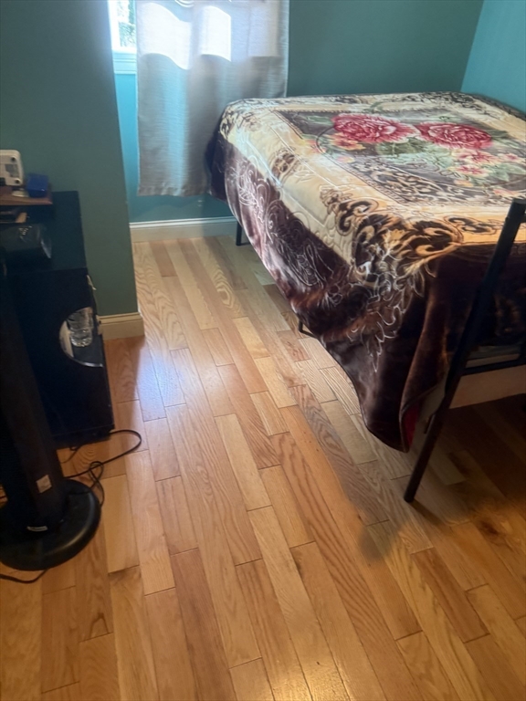 82 2nd Street Medford, MA 02155 - Photo 27 of 38 a bedroom with a bed and wooden floor