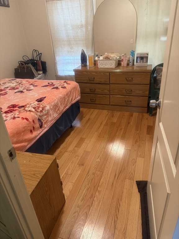 82 2nd Street Medford, MA 02155 - Photo 28 of 38 a bedroom with a bed and wooden floor