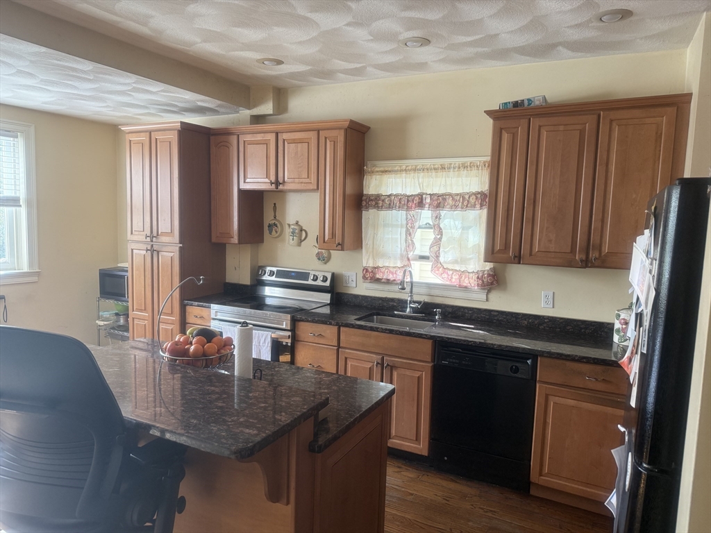 82 2nd Street Medford, MA 02155 - Photo 9 of 38 a kitchen with granite countertop a sink stove and cabinets