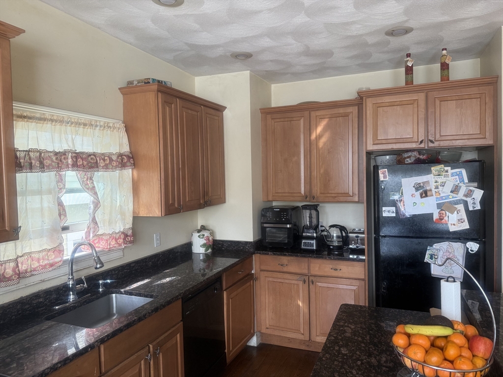 82 2nd Street Medford, MA 02155 - Photo 10 of 38 a kitchen with stainless steel appliances granite countertop a sink stove and cabinets