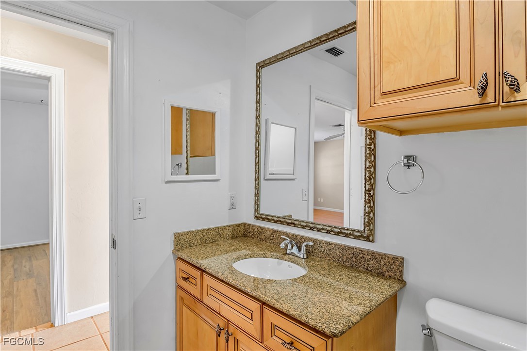 2301 Hibiscus Road Fort Myers, FL 33905 - Photo 25 of 40 a bathroom with a granite countertop sink a mirror and a toilet