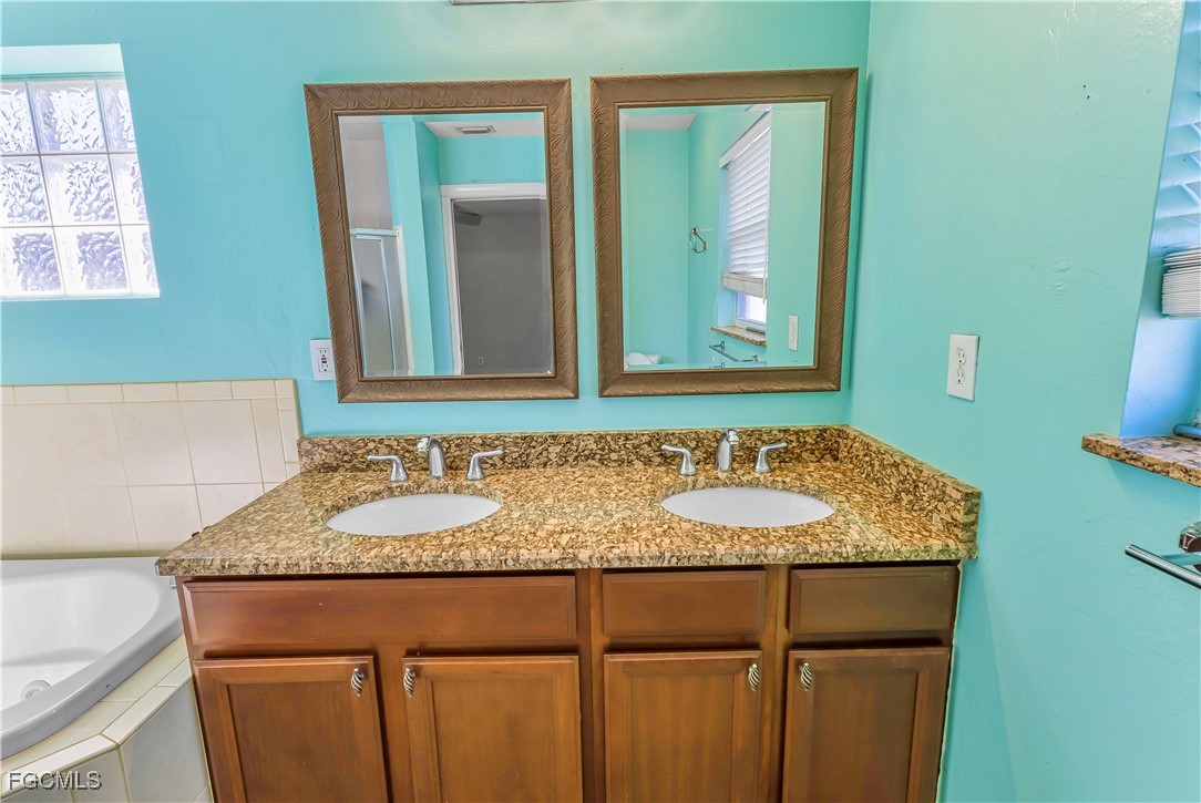 2301 Hibiscus Road Fort Myers, FL 33905 - Photo 32 of 40 a bathroom with a granite countertop sink and a mirror