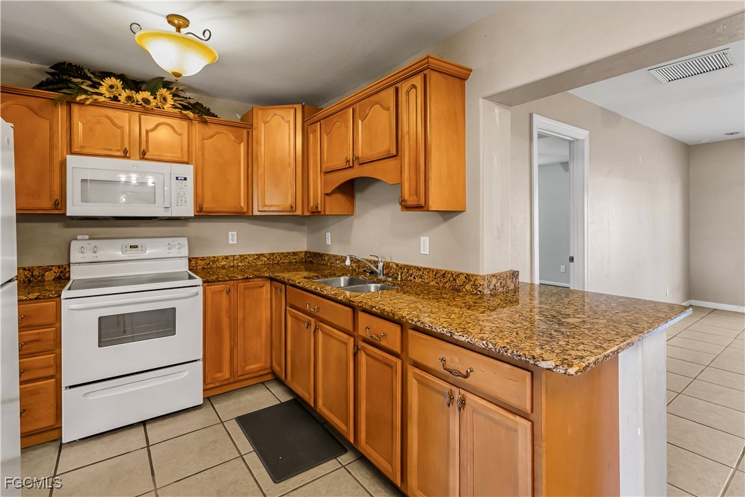 2301 Hibiscus Road Fort Myers, FL 33905 - Photo 6 of 40 a kitchen with stainless steel appliances granite countertop a stove a sink and a microwave
