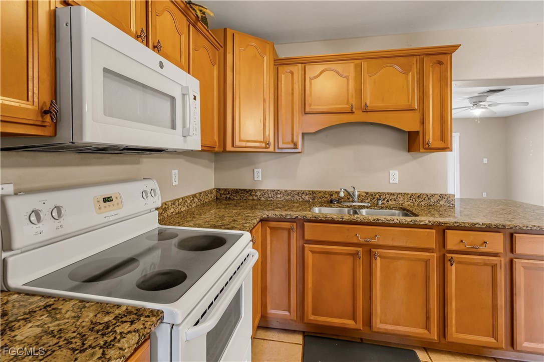 2301 Hibiscus Road Fort Myers, FL 33905 - Photo 7 of 40 a kitchen with granite countertop a sink a stove and cabinets
