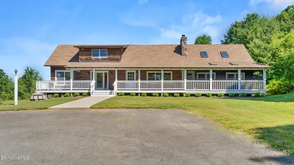 a front view of a house with a yard and trees