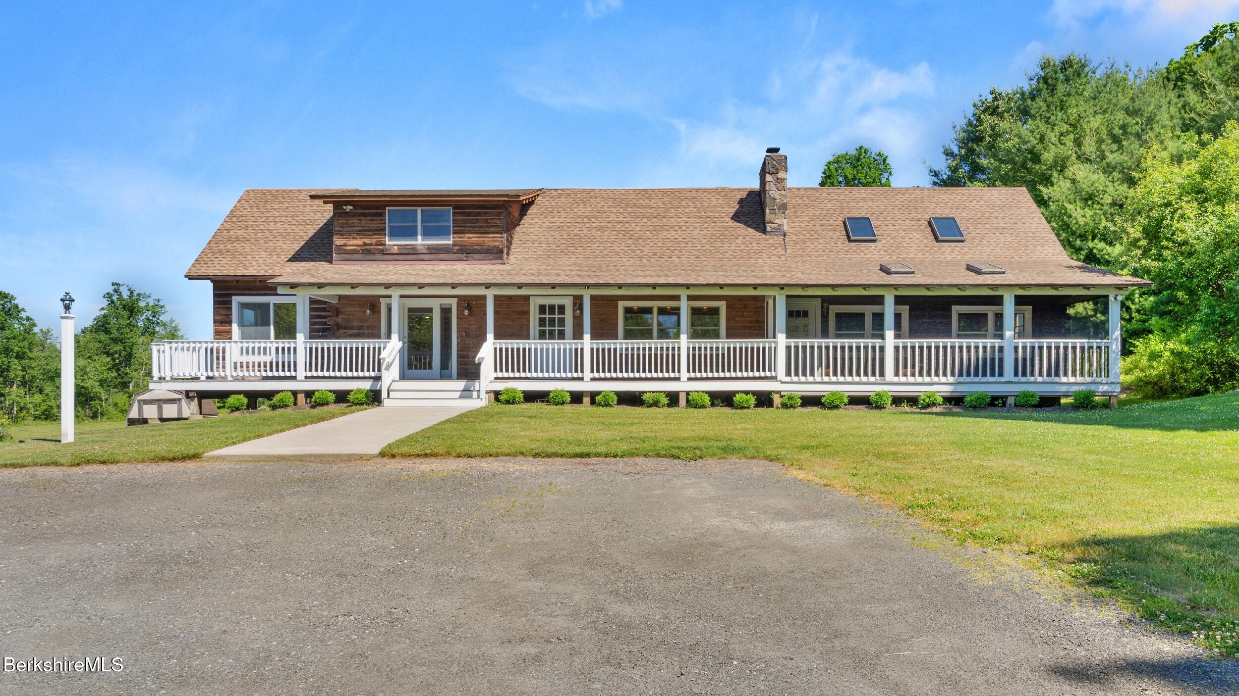 a front view of a house with a yard and trees