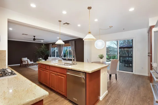 a kitchen with stainless steel appliances granite countertop a stove a sink and a microwave