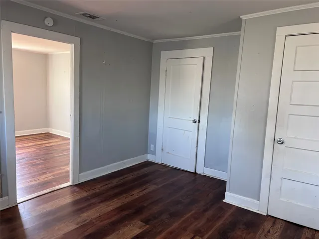 an empty room with wooden floor and closet