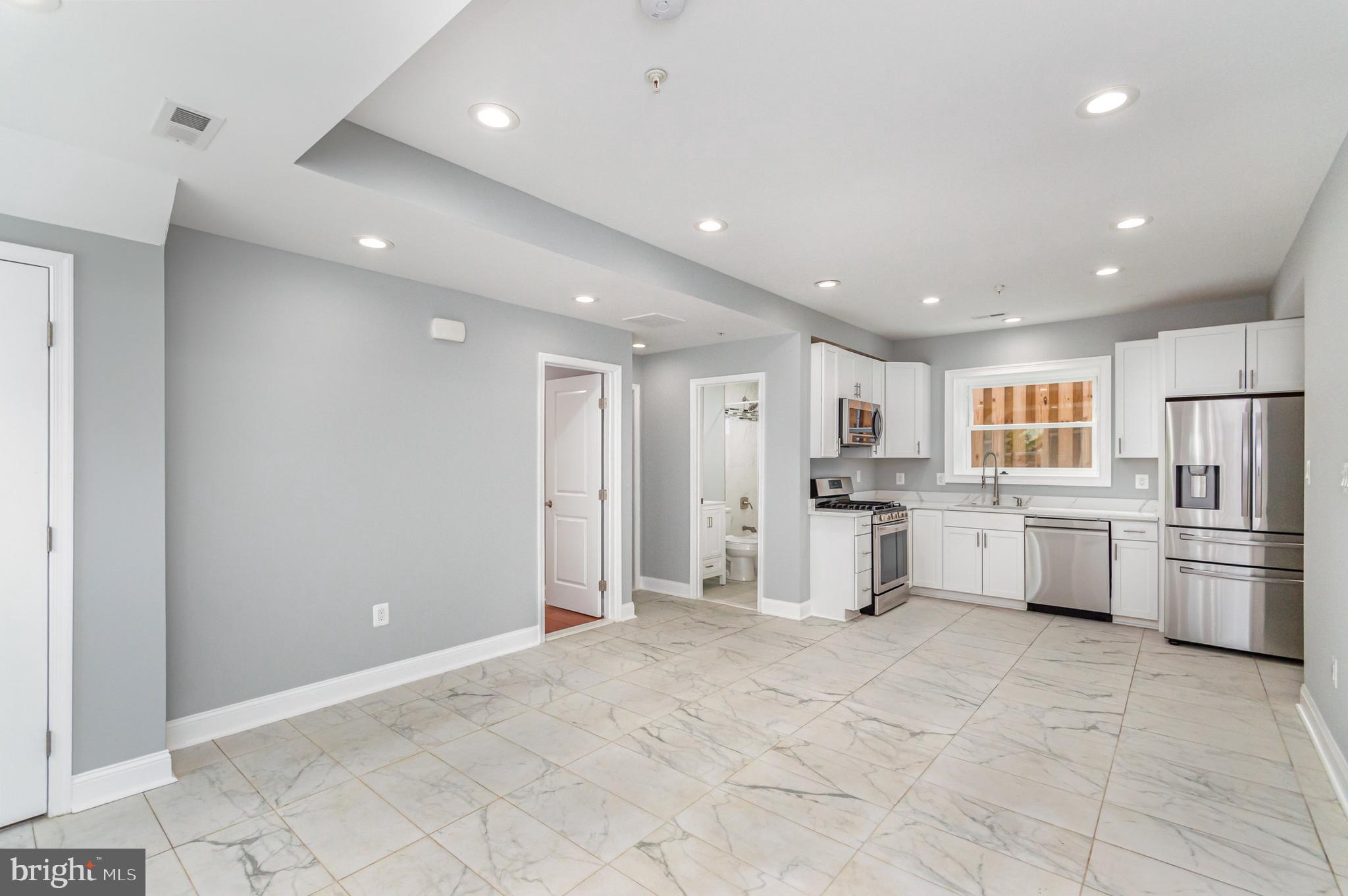 3110 Perry Street Mount Rainier, MD 20712 - Photo 20 of 24 a large white kitchen with white cabinets and stainless steel appliances