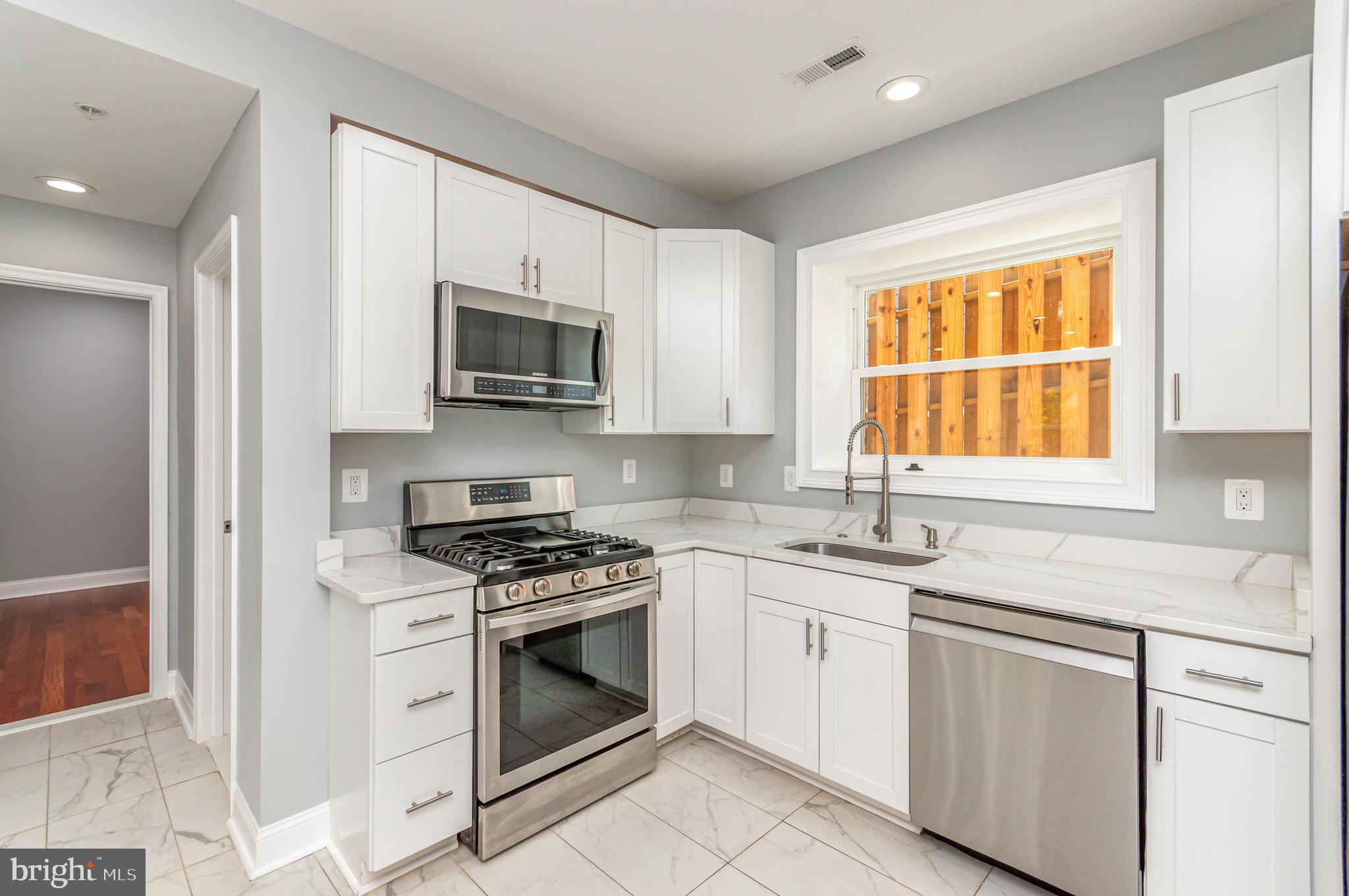 3110 Perry Street Mount Rainier, MD 20712 - Photo 3 of 24 a kitchen with granite countertop a stove sink and microwave