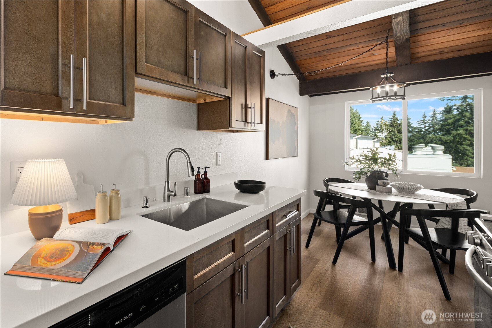 2020 Grant Avenue South, Unit A303 Renton, WA 98055 - Photo 8 of 17 a kitchen with stainless steel appliances a table chairs and a wooden cabinets