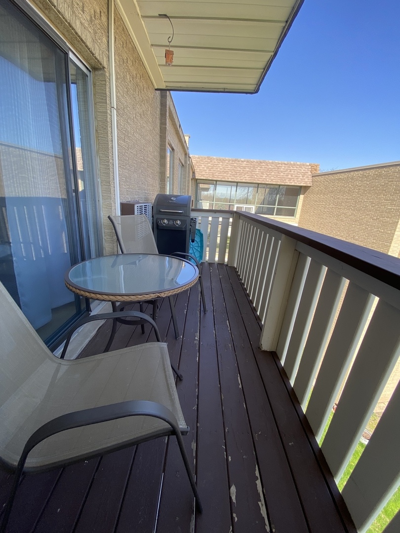 280 North Westgate Road, Unit 427 Mount Prospect, IL 60056 - Photo 20 of 23 a balcony with wooden floor table and chairs