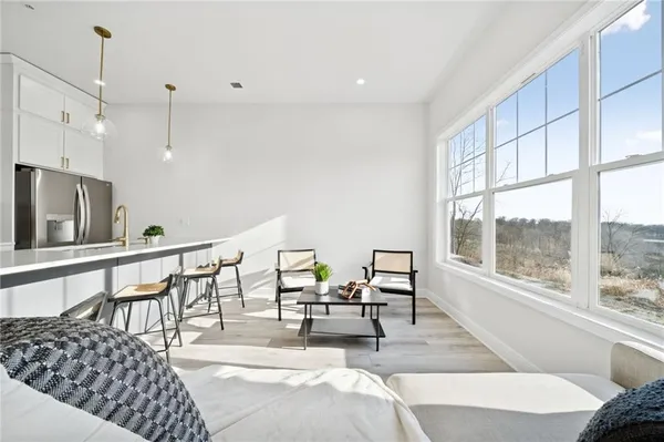 a living room with furniture a large window and chairs