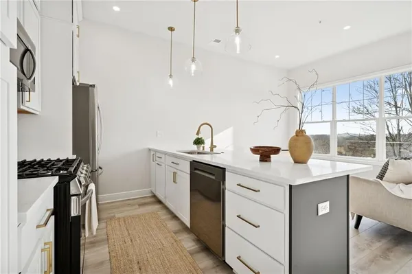 a kitchen with a sink stainless steel appliances and cabinets