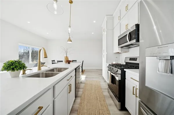 a kitchen with stainless steel appliances granite countertop a sink a stove and a refrigerator