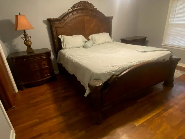 a large bed sitting in a bedroom next to a window