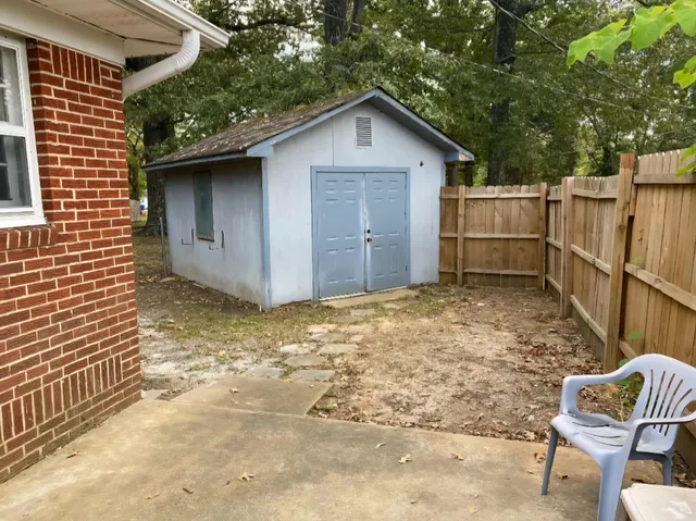 a view of backyard of house with wooden fence